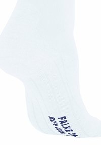 Biała sportowa skarpetka z prążkowaną teksturą i niebieskim nadrukowanym logo po boku. Zaprojektowana z myślą o komforcie i wsparciu podczas aktywności fizycznych.
