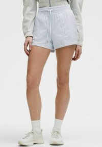 Pantalones cortos deportivos de color azul claro, hechos de una tela suave y liviana, con cinturilla elástica y cordón, y con bolsillos laterales.