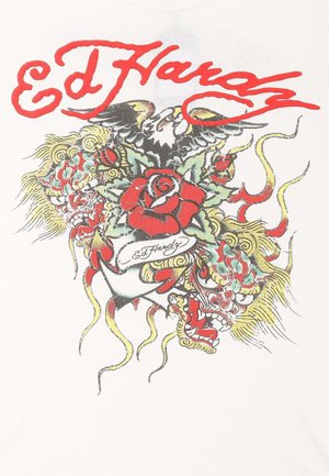 T-shirt bianco con una grafica colorata in stile tatuaggio, con testo rosso, una rosa, draghi e vortici in inchiostro verde, giallo e nero.
