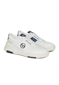 White athletic sneakers featuring a leather upper, navy accents, perforated details, and a thick sole with logo branding on the side.