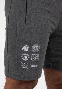 Grijze katoenen shorts met zijzakken, voorzien van witte bedrukte logo-details en nummers op het been. Gladde textuur en casual pasvorm.