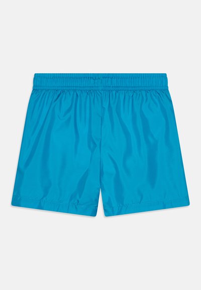 Bañador azul hecho de una tela suave y ligera; cinturilla elástica; largo por encima de la rodilla; sin patrones ni acentos visibles.