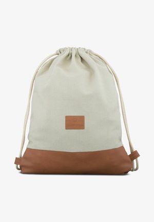 Zaino in cotone con cordoncino in beige chiaro e fondo in pelle marrone. Presenta una patch in pelle con logo sul davanti e cordini naturali.
