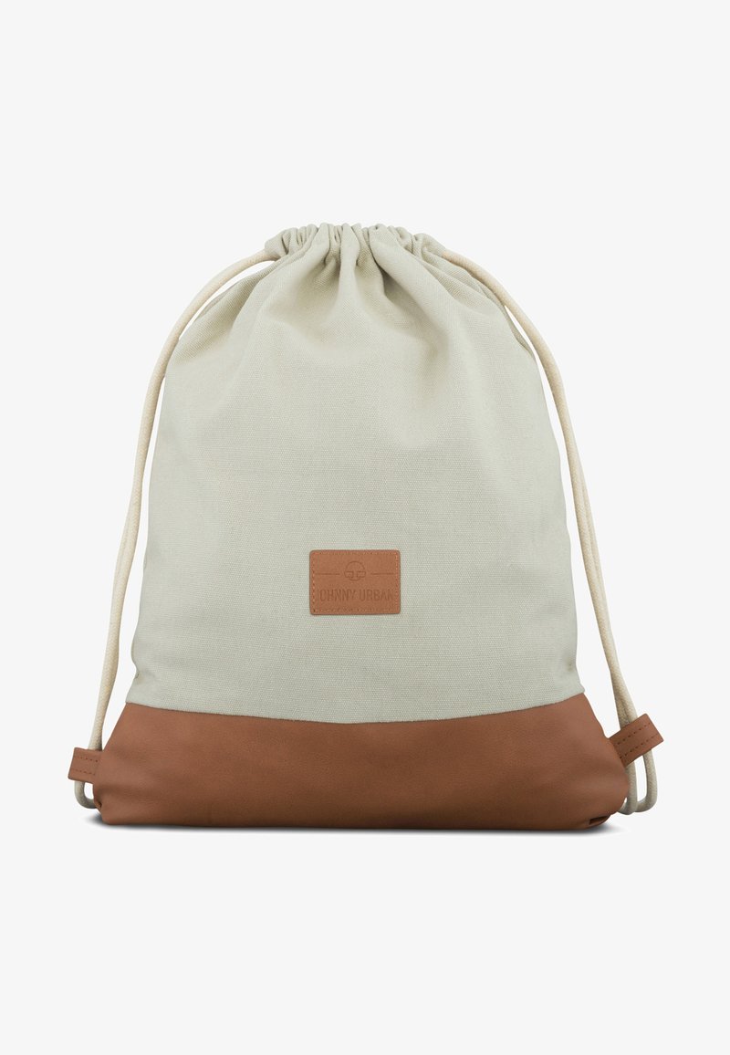 Kangasnarukku selkäreppu vaaleanbeigessä, ruskealla nahkapohjalla. Edessä on nahkainen logopatch ja luonnolliset narut.