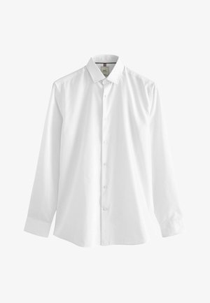 Bela dolgimi rokavi srajca iz bombaža, ki ima klasičen ovratnik, sprednje zapenjanje na gumb in ravno rob z manšetami na zapestjih.