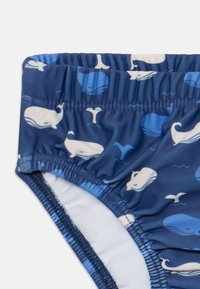 Blaue Badeshorts mit einem Muster aus weißen Walen und Wasserakzenten, aus leichtem, dehnbarem Stoff mit einem elastischen Bund gefertigt.
