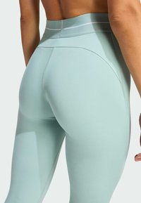 Höga, mintgröna leggings med en mjuk, stretchig textur. Har minimala sömmar och en kontrasterande midjebandsdesign.