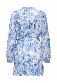 Robe longue à manches longues blanche à motif floral bleu, taille ceinturée, ourlet à volants et poignets boutonnés vue de dos.