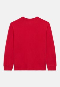 Κόκκινη βαμβακερή μπλούζα με μακριά μανίκια, στρογγυλή λαιμόκοψη και εφαρμοστά μανσέτα, με λεία υφή και χωρίς ορατά λογότυπα ή σχέδια.