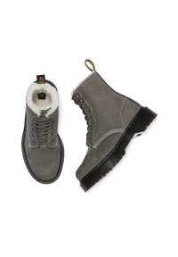Stivaletti ankle in suede grigi con fodera in pelliccia bianca, punta tonda, occhielli metallici e suola in gomma nera con scanalature. Etichetta di tiro sul retro.