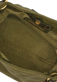 Interno di una borsa in tela verde oliva con texture a righe verticali, dotata di un unico scomparto, hardware dorato e bordi cuciti.
