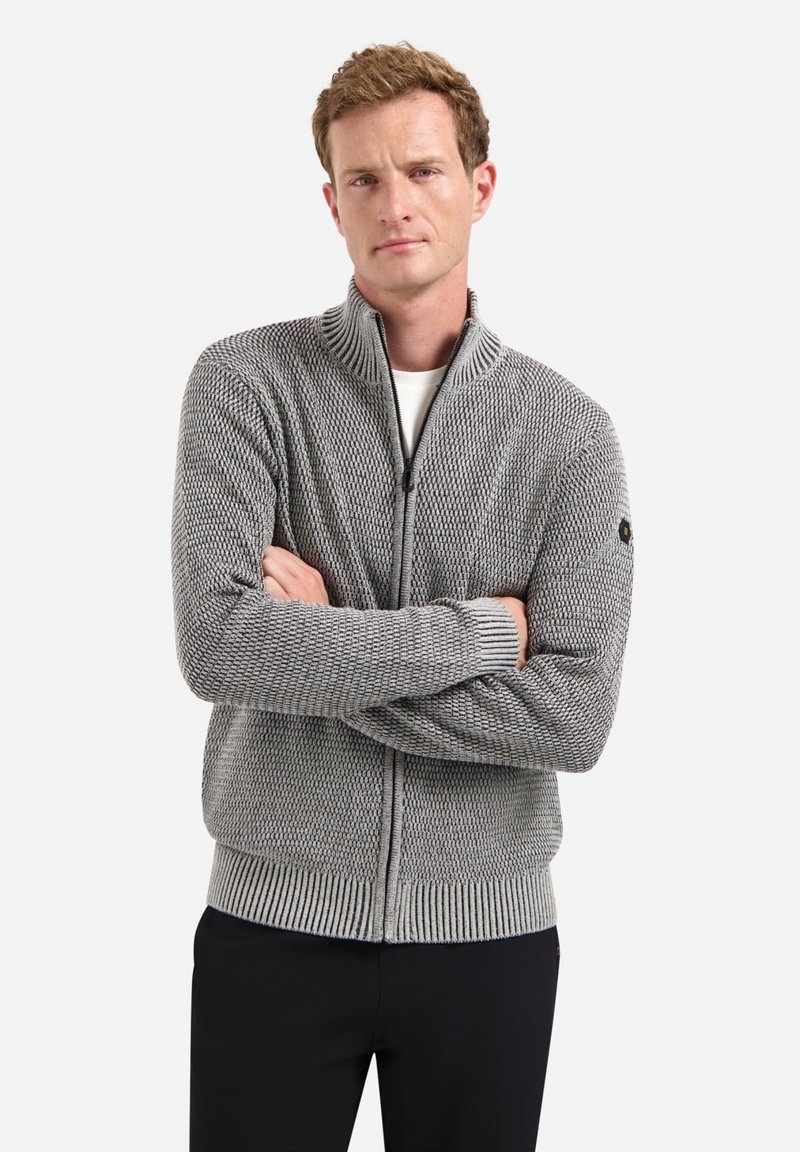 Grijze zip-up trui met een textuur gebreid ontwerp en geribbelde manchetten en zoom. Bevat een zwart logo patch op de linkermouw.