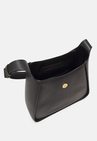 Sac à épaule en cuir noir avec une texture lisse, des bords arrondis et une fermeture à bouton en or. L'intérieur dispose d'une poche plaquée pour une meilleure organisation.