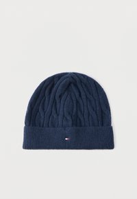 Σκούφος σε ναυτικό μπλε με πλεκτό σχέδιο καλωδίου, διπλωμένη ριμπ άκρη και μικρή λεπτομέρεια με κόκκινη, λευκή και μπλε σημαία στο κέντρο μπροστά.