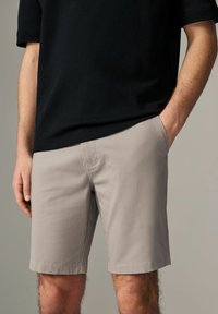 Lyse grå shorts med en afslappet pasform, lavet af et glat stof, med sidelommer og et rent, minimalistisk design.
