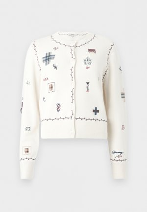 Valge nööbitav kardigan bordoopunaste õmblustega servadega ning erinevate väikeste siniste, bordoopunaste ja beežide tikanditega sümbolite ja tähtedega.