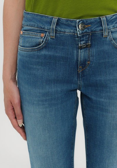 Blå denim jeans med rett snitt, som har fem lommer, kobbernitter og knappelukking. Glatt tekstur og middels vaskefinish.