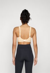 triaction by Triumph ENERGY LITE - Medium support sports bra - passion orange