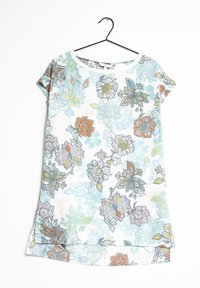 Tunique à manches courtes à fleurs en blanc, ornée de motifs floraux bleus, orange et verts. Le tissu semble lisse avec un léger éclat.