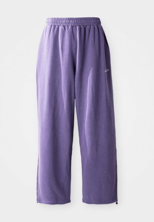 Purple sweatpants made of soft fabric, featuring an elastic waistband and relaxed fit, with zippers at the ankle for adjustments.