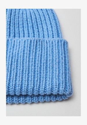 Bonnet tricoté bleu avec une texture côtelée, comportant un revers. Fabriqué en fil doux avec des détails de couture visibles.
