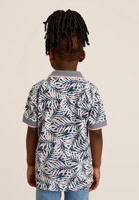 Korte mouw polo shirt in het wit met een levendig bladerenpatroon in blauw, rood en groen. Voorzien van een grijze kraag met contrasterende bies.