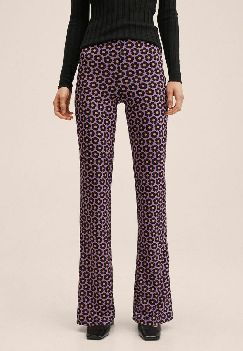 Spodnie w kształcie dzwonów w fioletowym materiale, z floralnym wzorem czarnych i różowych kwiatów. Średnio wysoki stan i miękka, gładka tekstura.