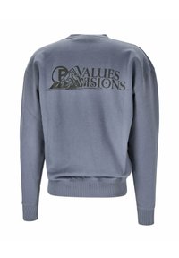 Grå sweatshirt med rundad hals, ribbade ärmslut och nederkant. Har djärv svart text och en berggrafik på ryggen. Slät textur.