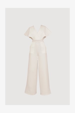 Mono blanco con escote en V profundo, mangas anchas y acampanadas, y cintura ceñida. Presenta pantalones de pierna ancha y un tejido suave y texturizado.