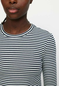 Langarmshirt in marineblau mit weißen horizontalen Streifen. Rippstruktur und runder Ausschnitt. Der Stoff wirkt weich und enganliegend.