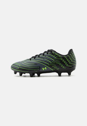 Chaussure de football Under Armour noire et verte avec crampons moulés et motifs dynamiques en lignes sur la partie supérieure.