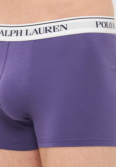 Moške vijolične bombažne bokserice s belim pasom, na katerem je natisnjen mornarsko modri tekst "RALPH LAUREN" in "POLO". Gladka tekstura in prilegajoč dizajn.