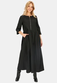 Czarna, długa sukienka z rękawami, z zamkiem z przodu, marszczonym dołem i bocznymi kieszeniami. Wykonana z lekkiego materiału, o gładkiej fakturze.