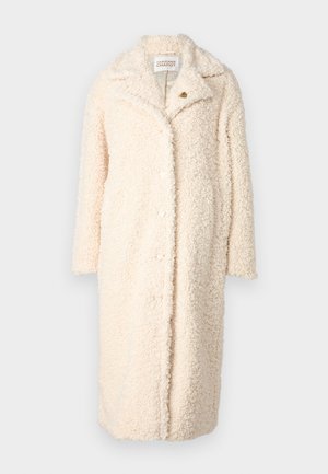 Crème-kleurige oversized jas van pluizige, textuurstof. Beschikt over een geknipt kraag en knoopsluitingen aan de voorkant.