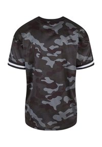 Camiseta de camuflaje en gris oscuro y negro, con textura de malla, mangas cortas y acentos de rayas blancas en las mangas.