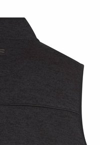 Schwarze Strickweste mit strukturierter Oberfläche, ausgestattet mit einem hohen Kragen und einer horizontalen Naht über den Rücken. Subtile Markenkennzeichnung am Kragen.