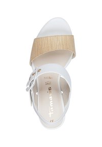 Sandal bianco con una ampia cinghia intrecciata beige e una cinghia alla caviglia regolabile. Materiale liscio, punta arrotondata, dettagli in metallo color oro.