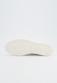 Weiße Gummi-Schuhsohle mit strukturierten Mustern, geprägt mit "paul green", kreisförmigen Griffen und einem glatten Kantendesign.