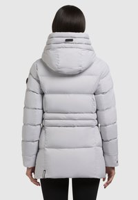 Lys grå pufferjakke med en aftagelig hætte, vandret syninger og sorte accenter. Har en rund krave og et slim fit design.