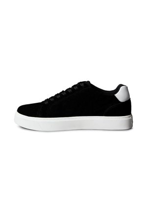 Schwarzer Low-Top-Sneaker mit schwarzen Schnürsenkeln und dicker weißer Sohle sowie weißem Fersenriemen, seitlich auf weißem Hintergrund dargestellt.