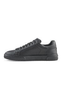 Sneakers in pelle nera con suola piatta, punta rotonda, chiusura con lacci e design minimalista. Presentano dettagli testurizzati e un colletto imbottito.