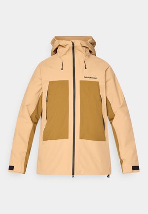 Giacca con cappuccio beige e marrone, con zip frontale, due grandi tasche anteriori, polsini regolabili e logo "Peak Performance" sul petto.