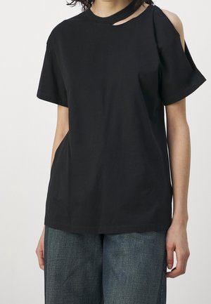 Sort bomuld T-shirt med korte ærmer og asymmetrisk udskæring ved skulderen. Har rund halsudskæring og afslappet pasform.