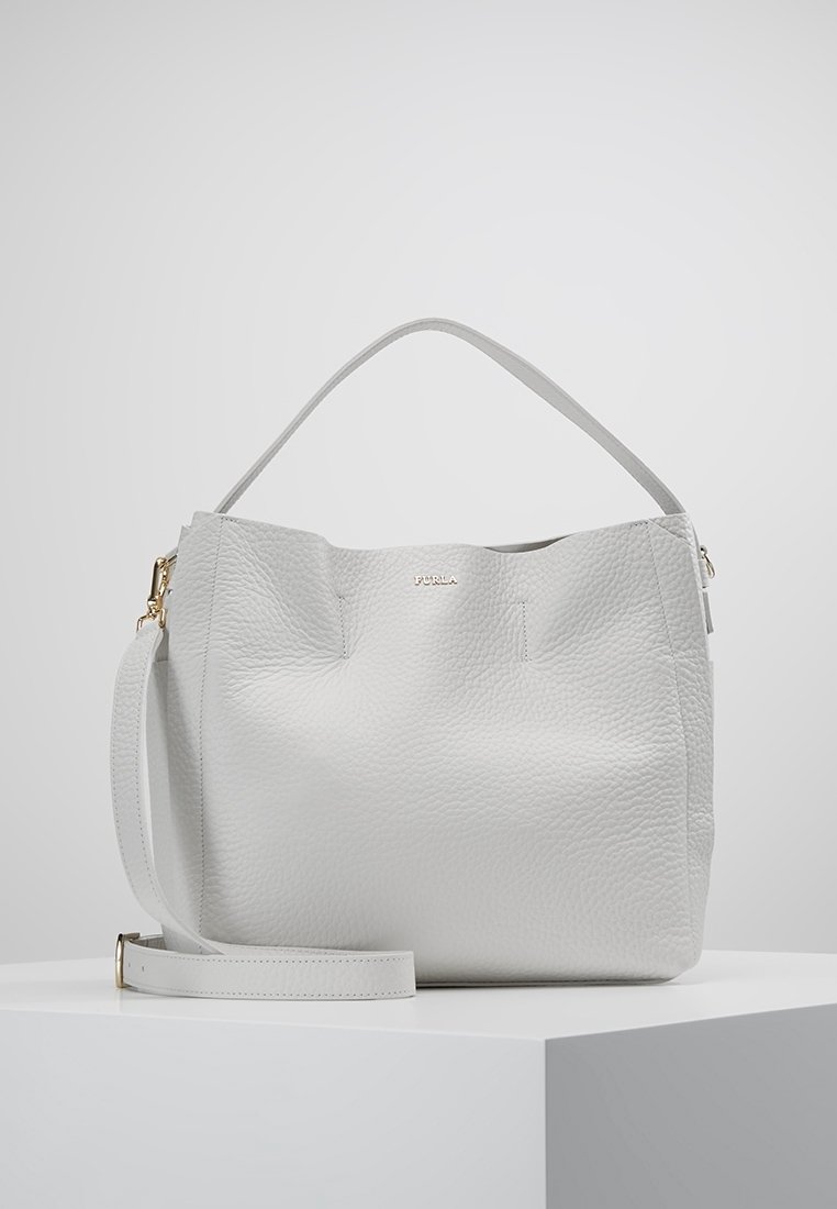Sac à main en cuir blanc texturé avec des anses courtes et longues, des ferrures dorées et un logo "FURLA" embossé à l'avant.