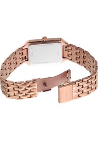 Montre rectangulaire Fossil avec un bracelet en acier inoxydable rose gold. Le fond est poli, avec des détails de couronne et de fermoir.