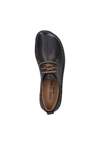 Scarpa in pelle nera con lacci marroni, dettagli cuciti e forma arrotondata. L'interno presenta un testo di branding e una fodera beige.