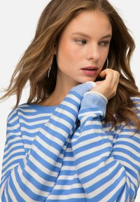 Blauw-wit gestreepte trui met een relaxte pasvorm, voorzien van lange mouwen en een ruime halslijn, gemaakt van zacht gebreid materiaal.
