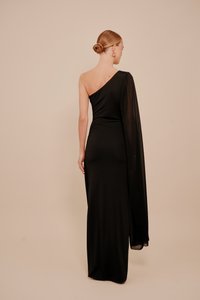 Fekete egyrészes vállpántos ruha, testhezálló sziluett, az egyik oldalon hosszú, áramló anyagredő, sima textúra, földig érő kivitel, minimalista stílus.