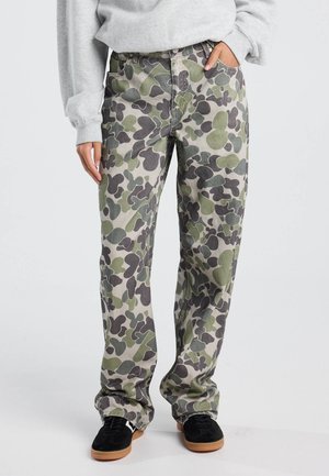 Camouflage cargo broek met een patroon van donkergroene en grijze vormen op een lichte achtergrond, gemaakt van een stevige stof en met een relaxed fit.