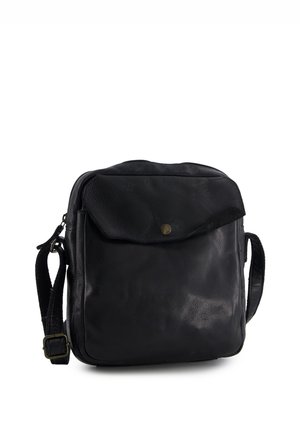 Schwarze Leder-Umhängetasche mit Frontklappentasche, gesichert durch einen Metallknopf, und verstellbarem Gurt mit Messingschnalle.
